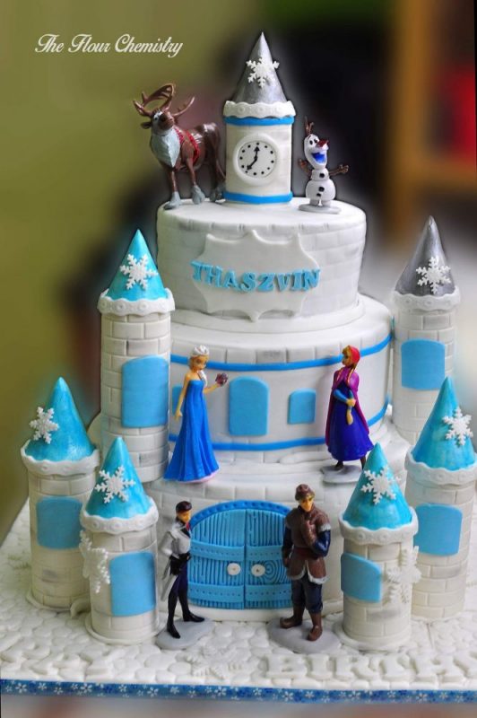 Four-tier Frozen cake with towers and toppers. By The Flour Chemistry