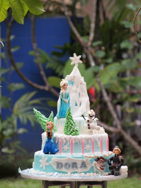 Three tier frozen cake with Elsa, Anna, Olaf, Sven and Kristoff. Made by Just Heavenly