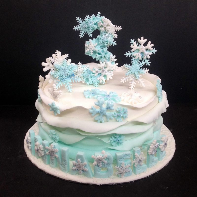 Frozen-themed ruffle cake with snowflake design toppers