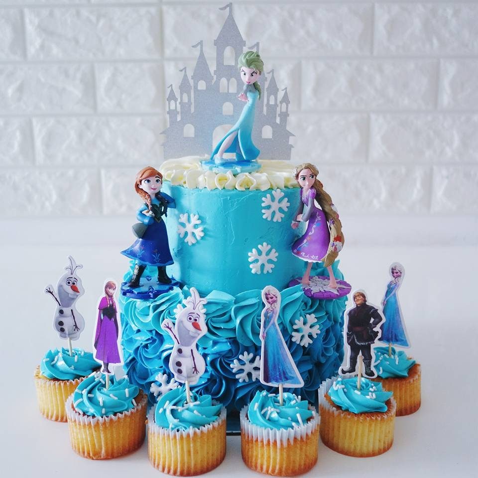Two-tier Frozen cake and cupcake set with Elsa and Anna (with Rapunzel thrown in for fun). Made by: River Ash Bakery. Order princess cakes in Singapore at Recommend.sg