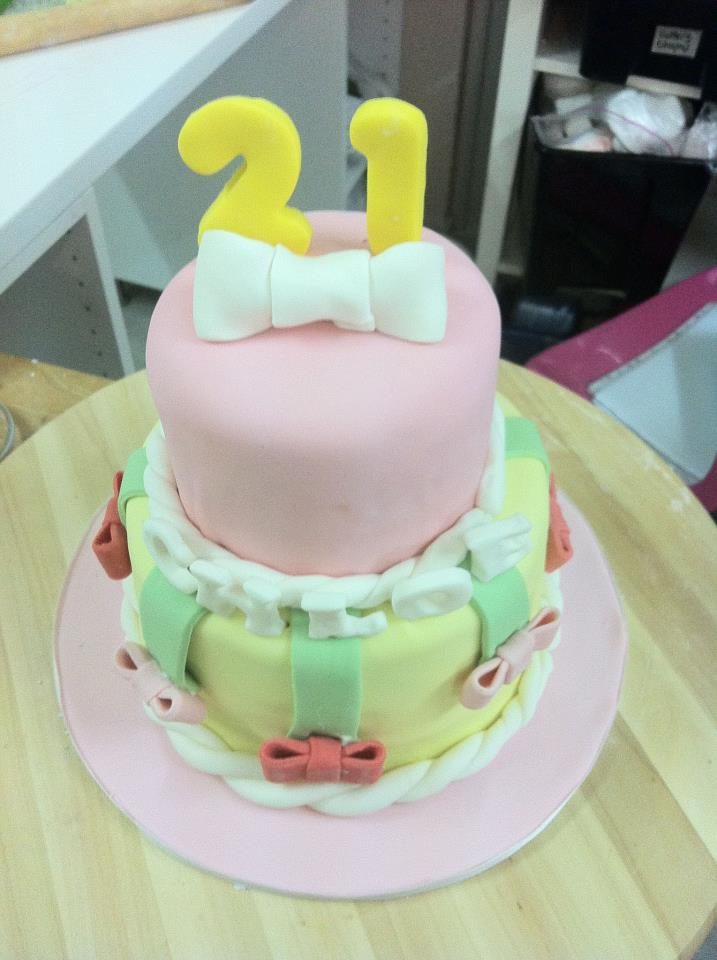  A colourful two tiered cake with fondant detailing and topper. Made by: My Fat Lady Cakes and Bakes Singapore - Recommend.sg