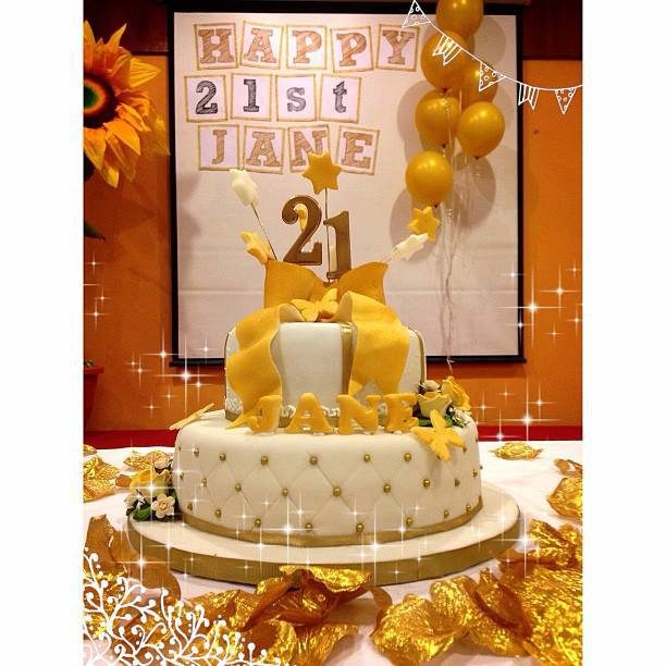 This two-tiered birthday cake looks perfect for this gold and white themed party. Made by: Temptations Cakes Singapore - Recommend.sg