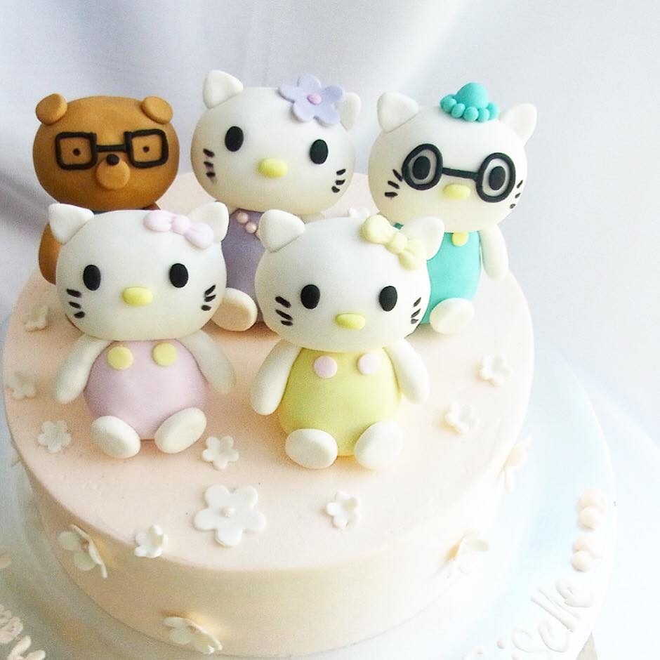 A round cake with fondant Hello Kitty family figures. Made by: Corine and Cake. Source