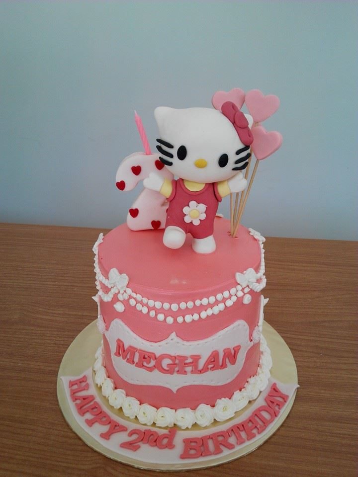 A pink and white themed tall round cake with Hello Kitty figure on top. Made by: My Fat Lady Cakes and Bakes. Source