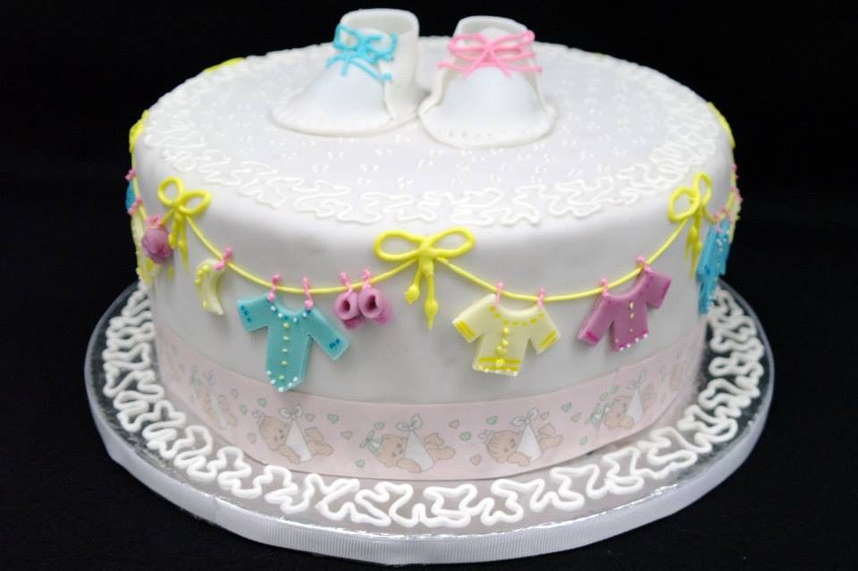 A white cake decorated with fondant cut outs and other simple decorations perfect for a baby shower. Made by: Temptations Cakes Singapore - Recommend.sg