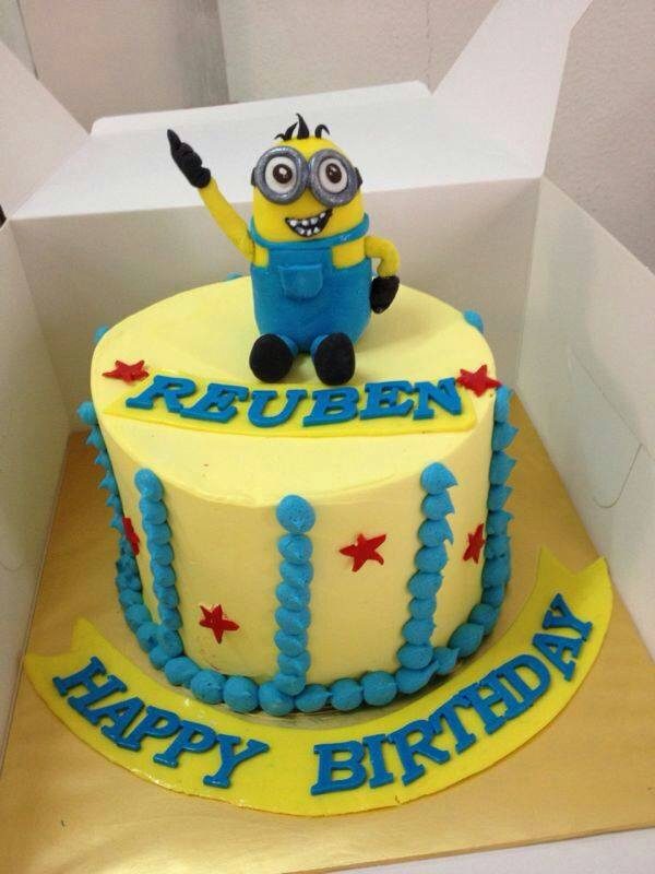 A tall round cake with yellow and blue buttercream frosting with an edible Minion cake topper.Made by: My Fat Lady Cakes and Bakes.Source