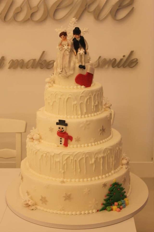 An all white wedding cake with Christmas themed decoration for a wedding held on Christmas day. Made by: Bonheur Patisserie.Source