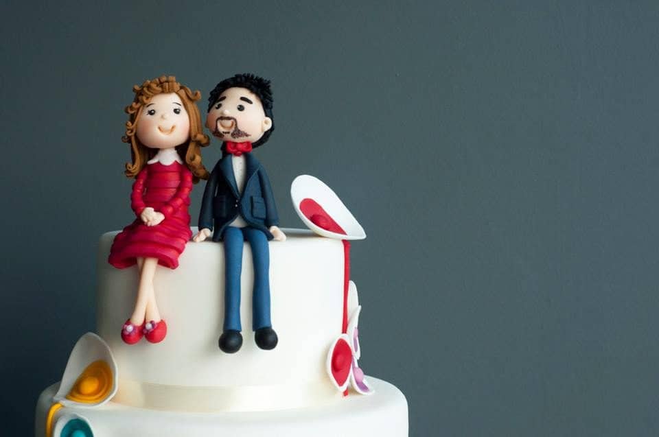 A modern wedding cake with edible figurines in casual attire to resemble the couple. Made by: Pulse Patisserie.Source