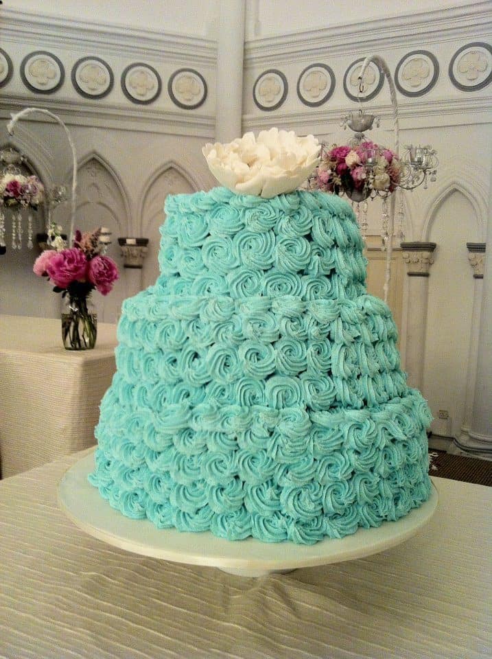 A three-tiered wedding cake with rosette buttercream frosting and peony sugar flower cake topper. Made by: My Fat Lady Cakes and Bakes.Source