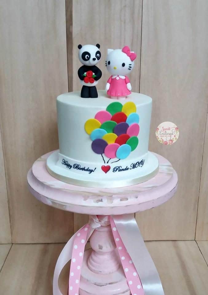 Instead of using other intricate shapes and details, this cake looks beautiful just by simple white fondant icing, balloon shaped fondant cut on the side, and a couple of Hello Kitty and panda toppers.. Made by: Sweet Endings.Source