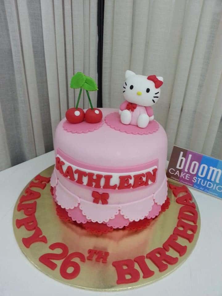 A simple round cake covered with fondant icing, arranged to look like drapery seems more interesting with a couple of cherries and a Hello Kitty fondant figure on top of it. Made by: Bloom Cake Studio.Source