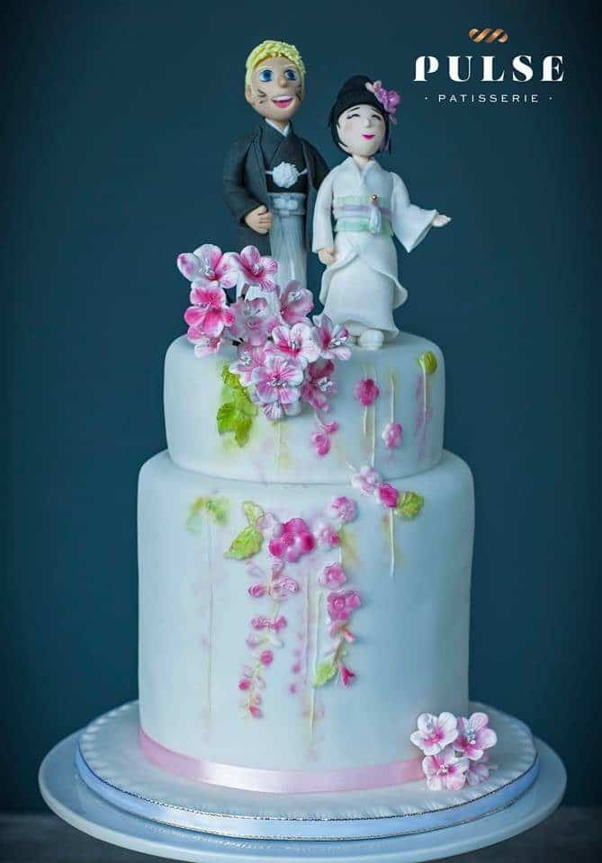 A Japanese themed singapore wedding cake with figurines of the bride and groom in Japanese traditional wear as the cake topper. Made by: Pulse Patisserie. Source
