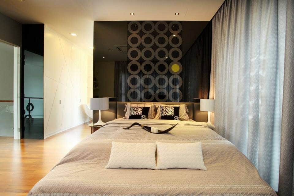 Mirrored wall above headboard with geometric pattern for this condominium in Puchong